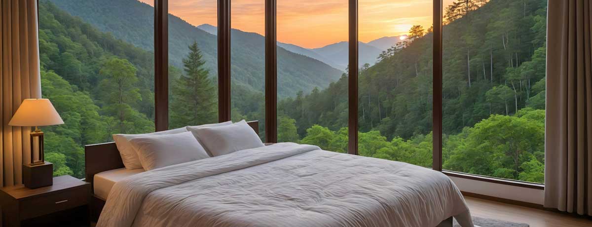 bed-bb-bergen Panoramic bedroom with king bed and floor-to-ceiling windows overlooking green mountain valley at sunrise