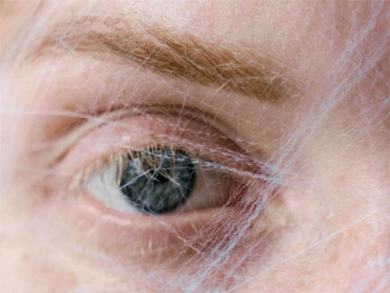 Close-up van een ouder oog met fijne rimpels, opvallende wenkbrauw en huidtextuur in zachte natuurlijke kleuren