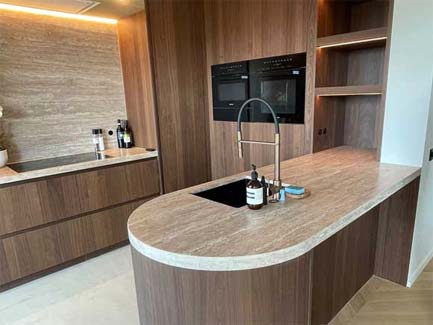 Luxe moderne keuken met op maat gemaakte houten kasten en marmeren eiland, ingebouwde ovens en stijlvolle gootsteenarmatuur